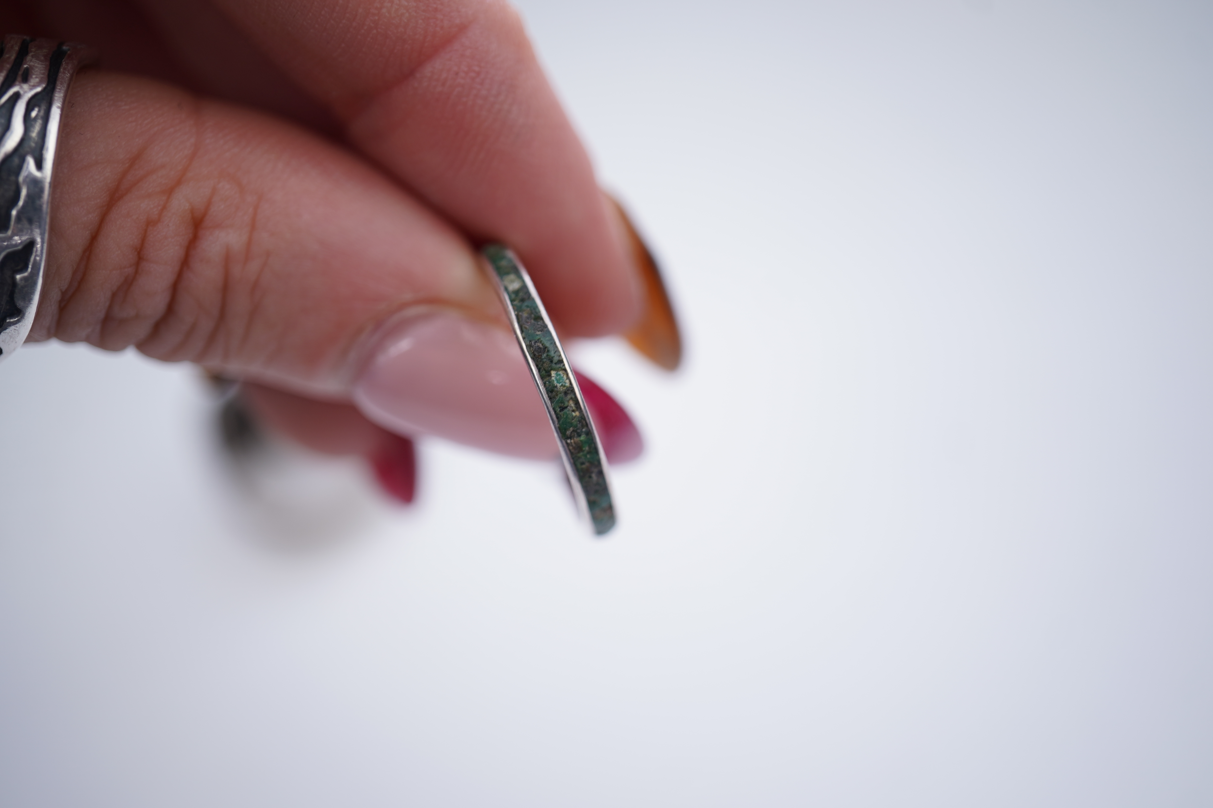 A collection of silver jewels, comprising: a bangle; a chain necklace suspending two winding toothpicks, one with toothpick deficient; a rope twist chain; a pair of cufflinks with the initials DBH; a pendant of abstract